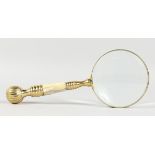 A LADIES MAGNIFYING GLASS with mother-of-pearl and brass handle.
