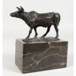 A SMALL BRONZE MODEL OF A COW, on a marble base. 6ins long.