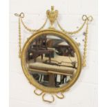 A REGENCY DESIGN GILT FRAMED CIRCULAR MIRROR, 19TH CENTURY, with urn finial, ribbon and harebell