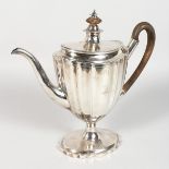 A GEORGE III FLUTED COFFEE POT, with wooden finial and handle, on a shaped oval base. Crested.