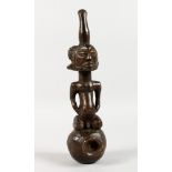 AN AFRICAN CARVED WOOD FIGURE AS A PIPE. 10ins long.