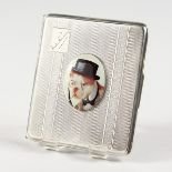 AN ENGINE TURNED SILVER CIGARETTE CASE, with an oval of a dog wearing a hat. Birmingham 1928.