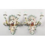 A GOOD PAIR OF MEISSEN TWO-BRANCH WALL SCONCES, encrusted with flowers and cupid, and painted with