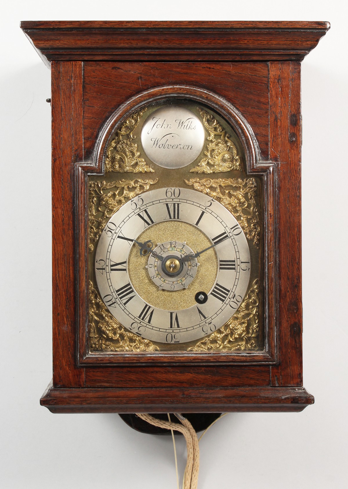 AN 18TH CENTURY OAK CASED HOODED WALL CLOCK, with an arched brass dial, silvered chapter ring,