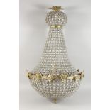 A LARGE CUT GLASS AND BRASS CHANDELIER. 36ins high.