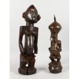 TWO AFRICAN CARVED WOOD FIGURES. 18ins and 14ins high.