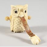 A CARVED BONE OWL TAPE MEASURE.