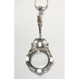 A SILVER AND OPAL SPY GLASS on a chain.