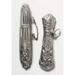 TWO SILVER NEEDLE CASES.