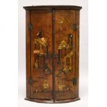 A 19TH CENTURY LACQUERED PINE BOWFRONT HANGING CORNER CUPBOARD, the pair of doors decorated in the