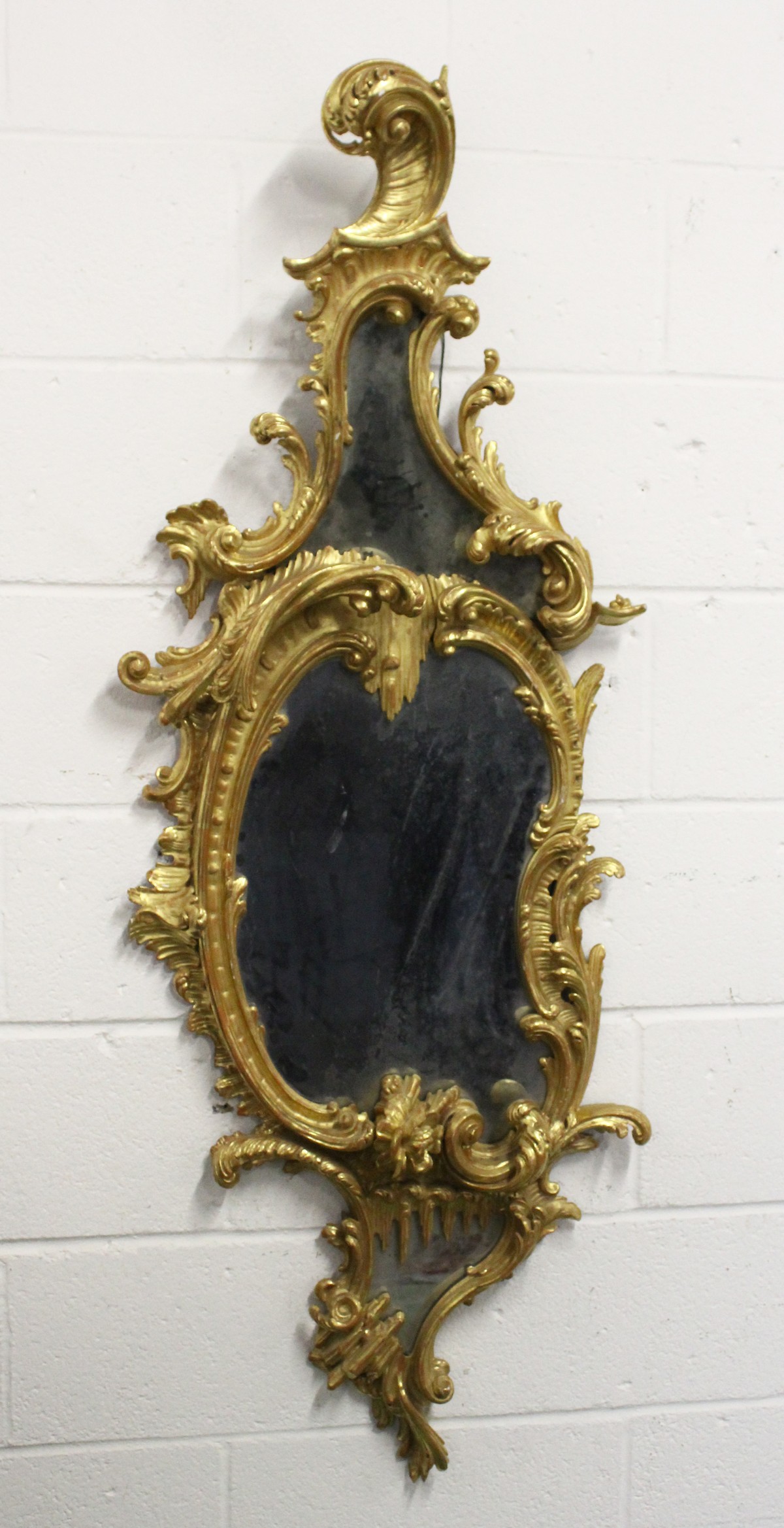 A GOOD CHIPPENDALE CARVED AND GILDED ROCOCO DESIGN MIRROR with scrolls and foliage. 4ft 10ins high x