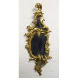 A GOOD CHIPPENDALE CARVED AND GILDED ROCOCO DESIGN MIRROR with scrolls and foliage. 4ft 10ins high x