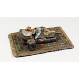 A VIENNA STYLE COLD PAINTED BRONZE MODEL OF A LADY SLEEPING ON A BED, on a Persian rug. 6.25ins