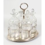 A GOOD GEORGE III OVAL FOUR BOTTLE CRUET, with four decanters and stoppers, the frame with gadrooned