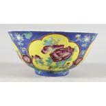 A CHINESE CIRCULAR PORCELAIN BOWL, the blue and yellow ground exterior painted with flowers. 6ins