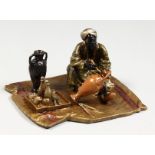 A SMALL VIENNA STYLE COLD PAINTED BRONZE GROUP OF A MAN PAINTING A VASE ON A CARPET. 4ins wide.