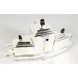 AN ART DECO STYLE PLATED THREE-PIECE TEA SET ON STAND. 15ins long.