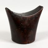 A GOOD CARVED WOOD NECK REST. See label on reverse. 6ins high.