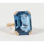 A 9CT GOLD AND BLUE STONE RING.