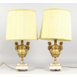 A PAIR OF GILDED SPELTER URN SHAPED TABLE LAMPS, on marble bases. 14ins high.