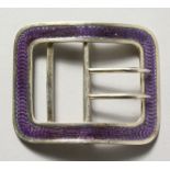 A silver and blue enamel buckle.