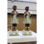 A pair of lustre glazed pottery models of blackamoors.