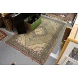 A Persian rug, beige ground with central floral motif and similar corner decoration.