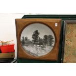 A large painted circular porcelain dish mounted in an oak frame.