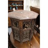 An eastern carved wood octagonal shaped table, with pierced folding stand (faults).