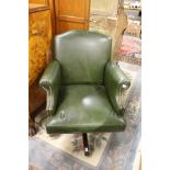 A green leather upholstered office swivel armchair.