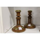 A pair of walnut and brass candlesticks.