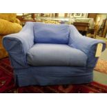 A modern armchair with blue loose covers.