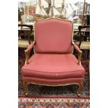 A French style open armchair with crimson upholstery.