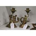 A pair of ornate cast brass figural candlesticks in the classical manner.