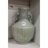 A Chinese celadon glazed moulded porcelain twin handled vase.