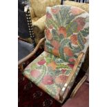 An 18th century continental walnut framed open armchair with needlework upholstered back and seat.