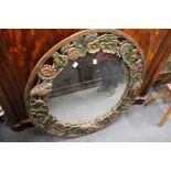 A large decoratively carved circular wall mirror.