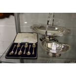 A small silver pedestal dish, a cased set of six silver coffee spoons and a plated cake basket.