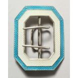 A silver and turquoise enamel buckle.