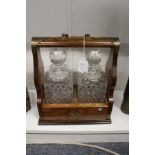 An oak tantalus with a pair of cut glass decanters.