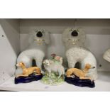 A pair of Staffordshire spaniels, a pair of sheep spill vases and a pair of reclining greyhounds.