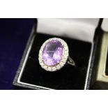 A dress ring set with a large amethyst coloured stone.