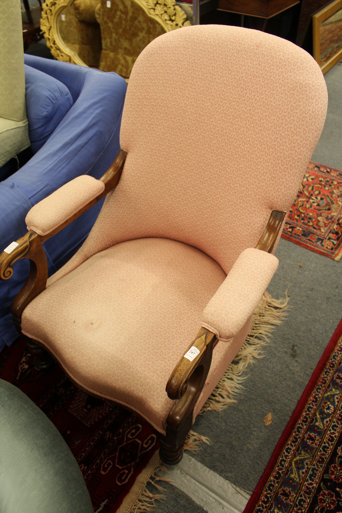 A Victorian mahogany framed open armchair with turned front legs.