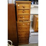 A tall pine modern chest of drawers and a similar smaller chest.
