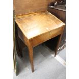 A 19th century elm desk with rising lid, on tapering square legs.