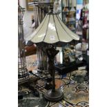 An Art Nouveau style lamp base modelled as a standing female nude with an opaque glass shade.