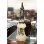 A small cast white metal model of a religious figure on an alabaster base.