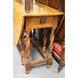 An oak drop leaf gate leg dining table on barley twist legs.