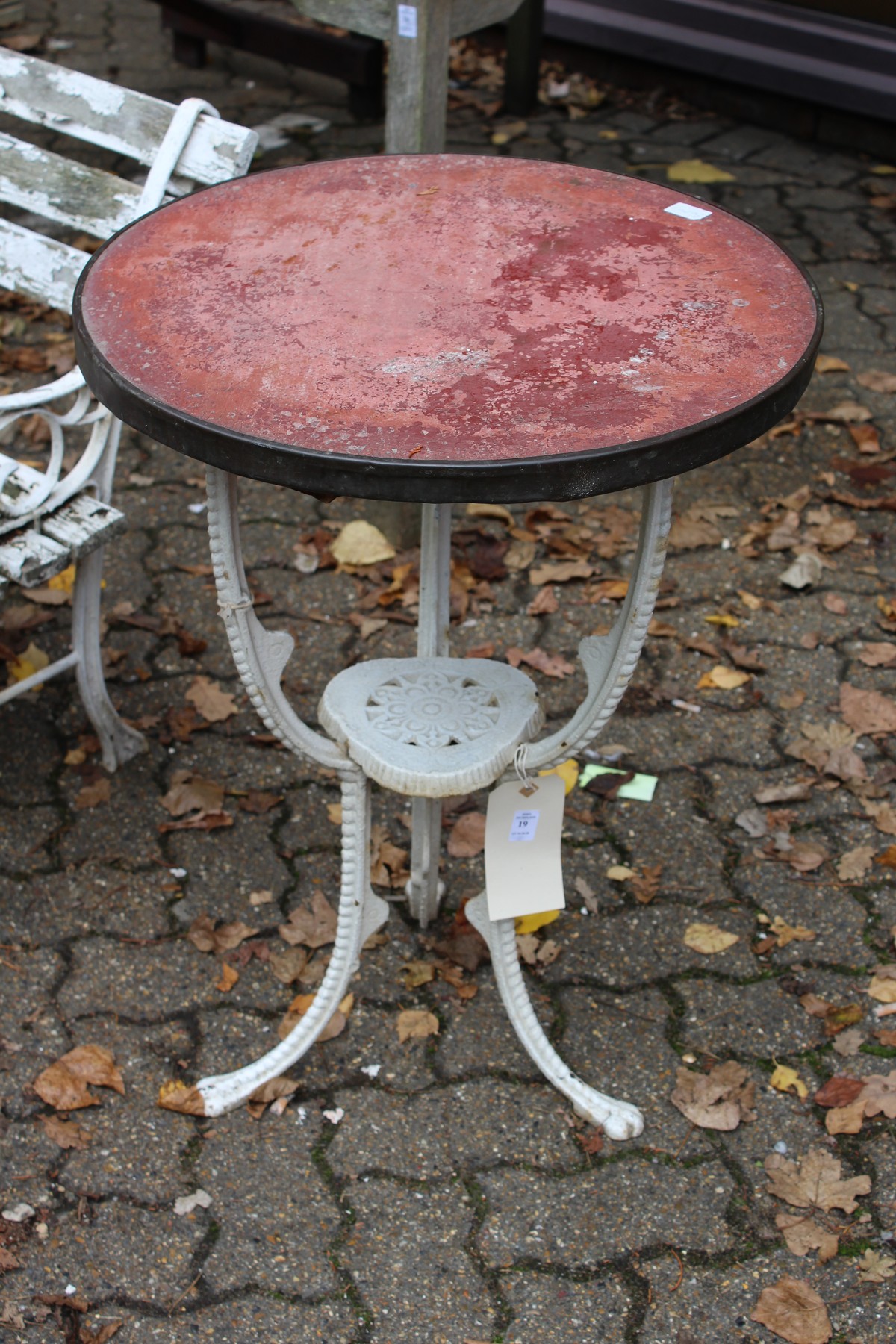 A small cast iron garden table with circular top.