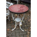 A small cast iron garden table with circular top.